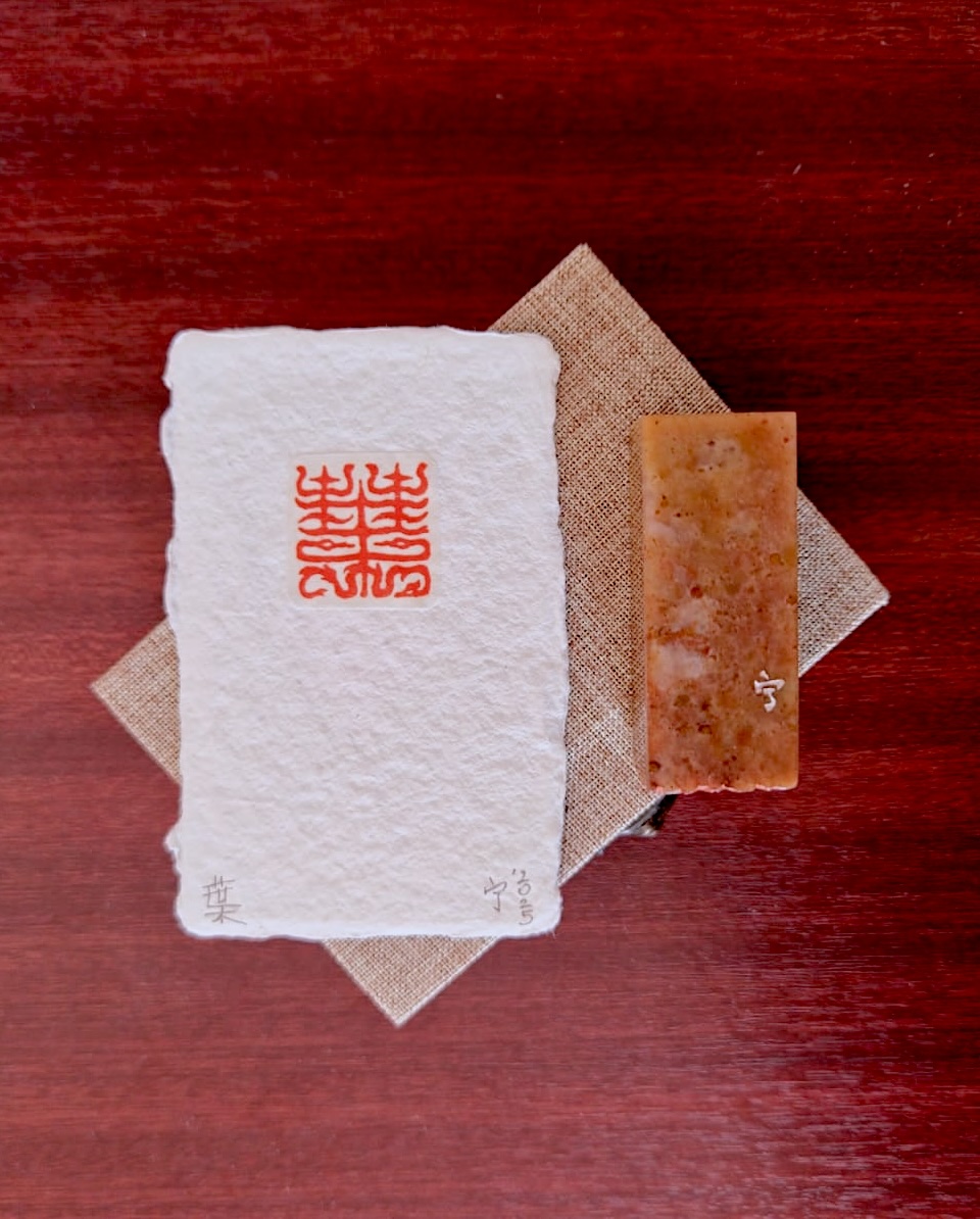 Family seal impression beside its carved stone in a keepsake box