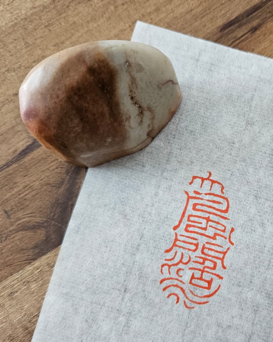 Small stone seal beside its impression on handmade paper