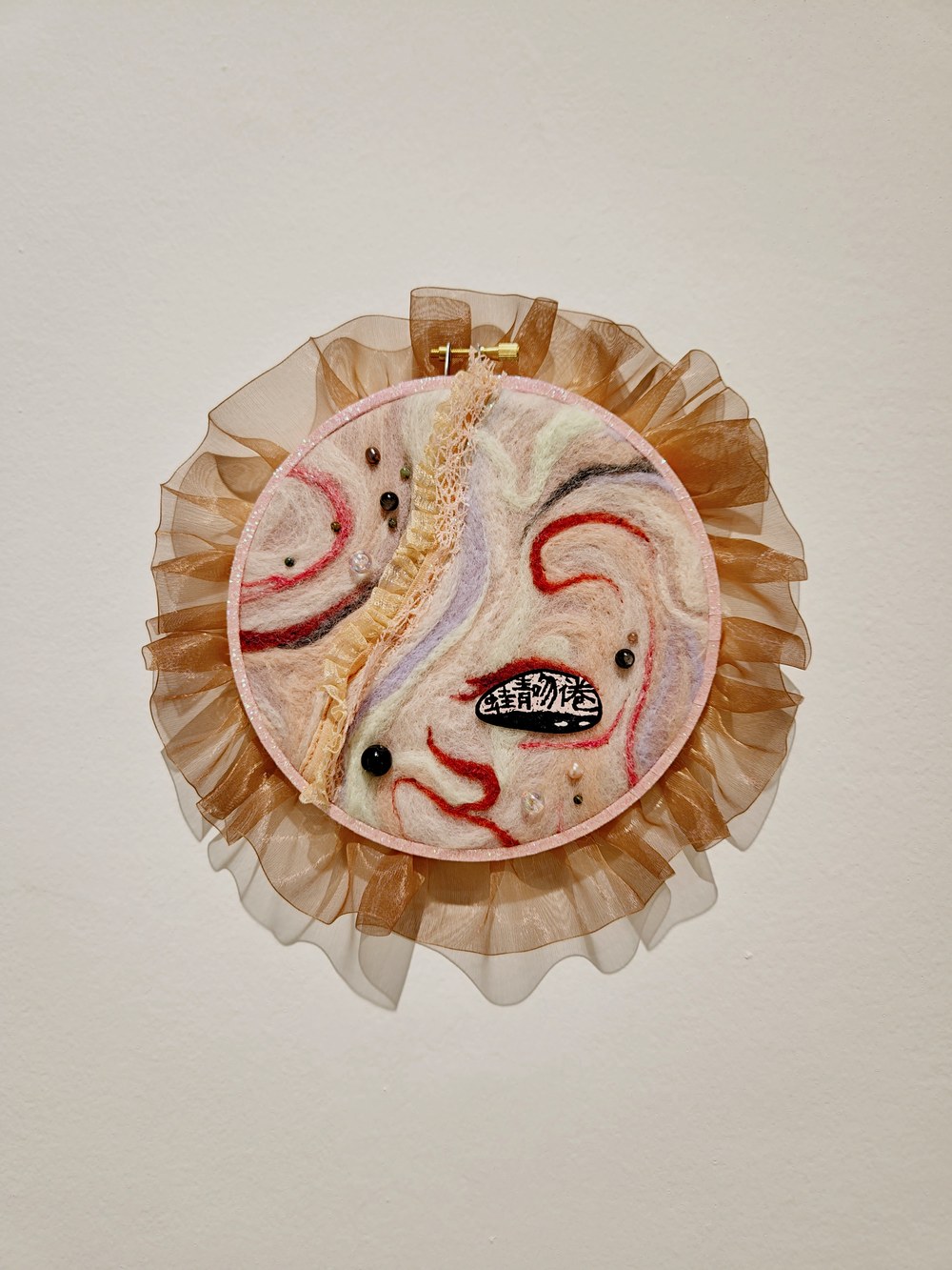 Round felt piece with red seal impression