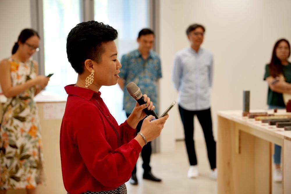 Michelle speaking at a public event with seal tools on the table beside her
