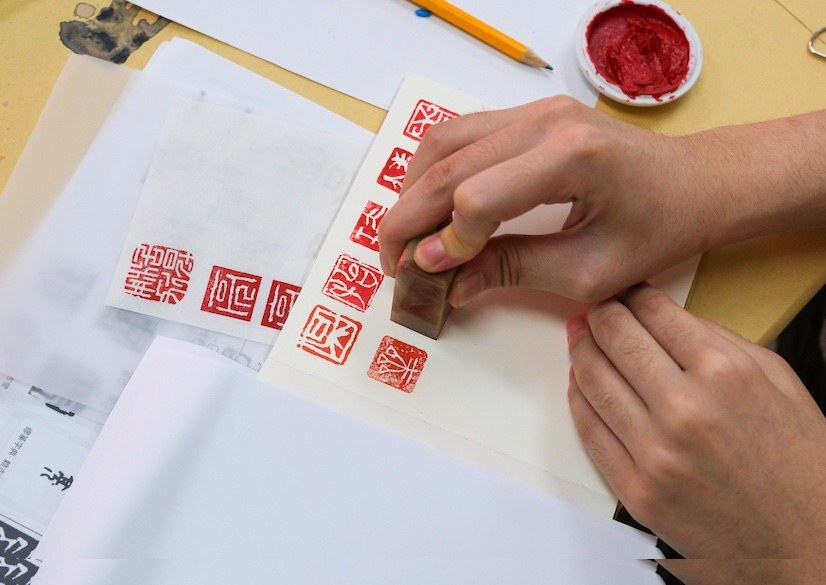 Participant inking their finished seal